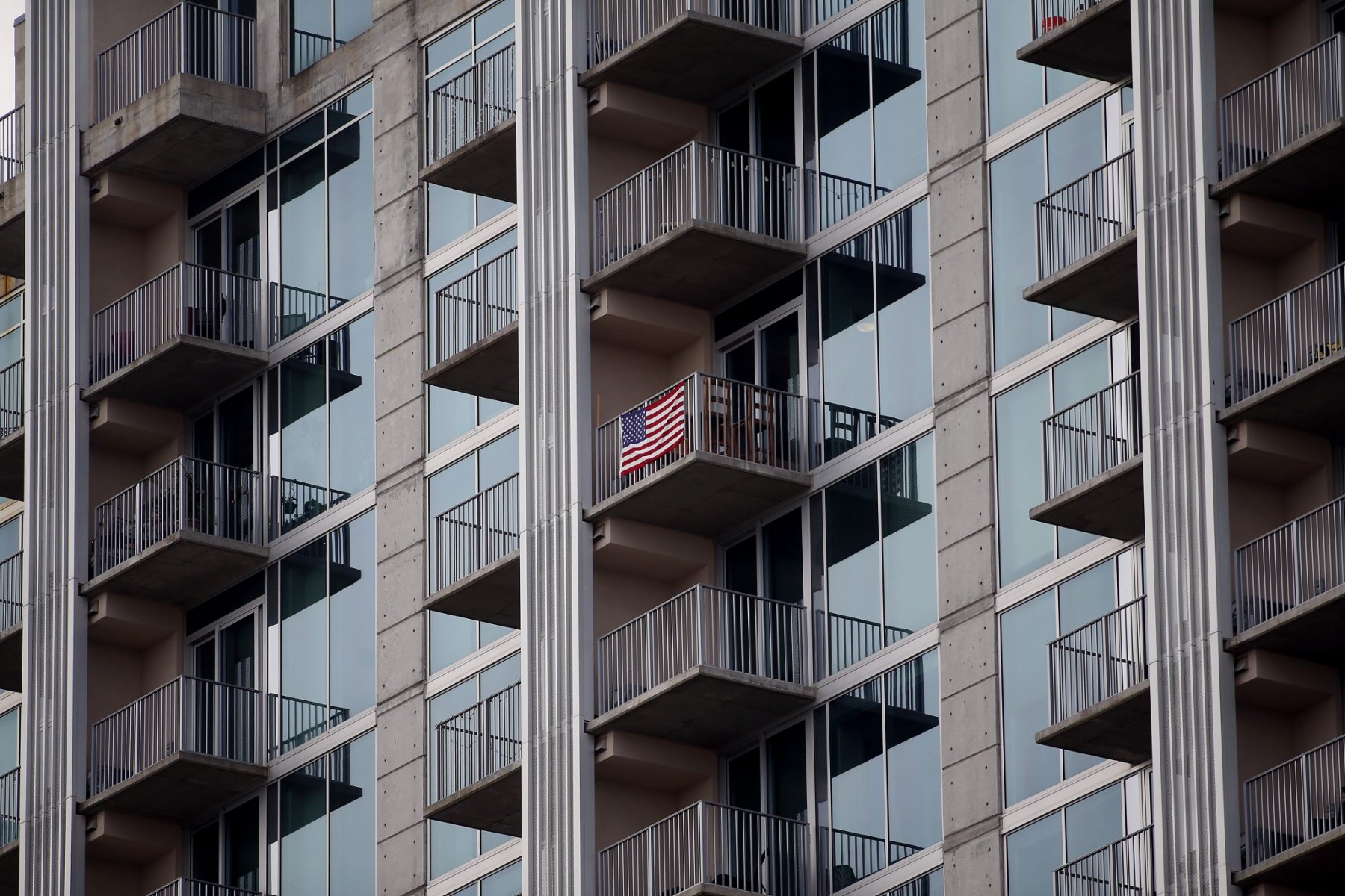 A lone American flag on the balcony of a high-rise in Downtown Raleigh the first work day after the Wake County ‘Stay at Home’ proclamation. March 30, 2020. Raleigh, NC
