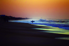A surfer hits the waves at sunrise in Surf City, NCSeptember 22, 2019. Surf City, NC