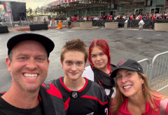 family of four smiles while standing in front of Lenovo Center ahead of Carolina Hurricane's game