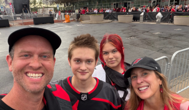 family of four smiles while standing in front of Lenovo Center ahead of Carolina Hurricane's game