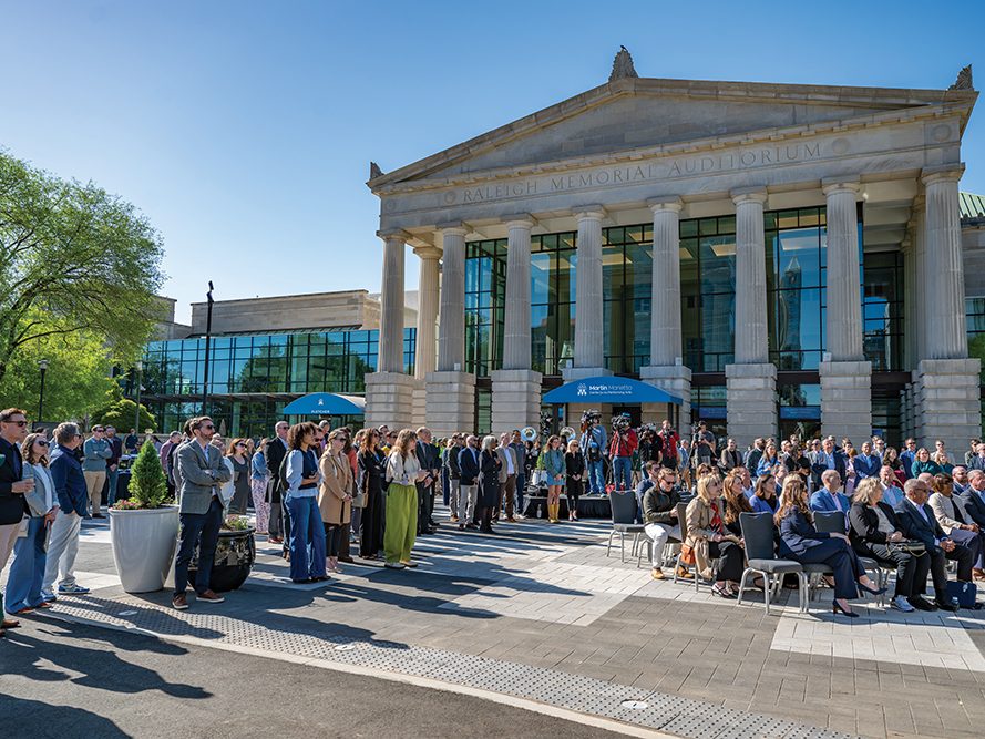 Guests stand in front of the performing arts center at the unveiling ceremony